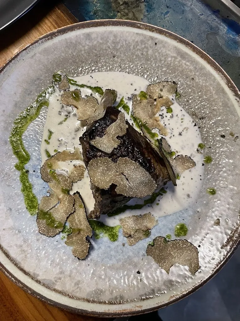 Viande et lamelles de truffe dans une assiette en grès